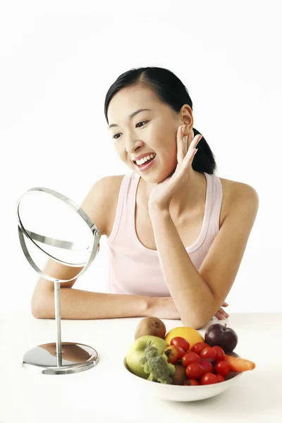 Frau Blickt Den Spiegel Neben Ihr Eine Schüssel Mit Obst — Stockfoto