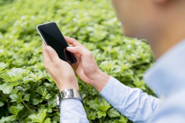 Dışarıda cep telefonu kullanan bir adam.