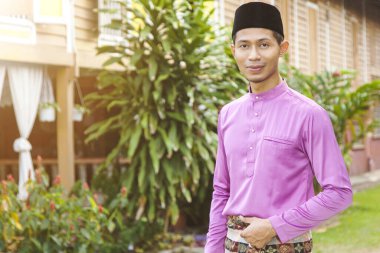 Evinin önünde duran Müslüman bir adam.