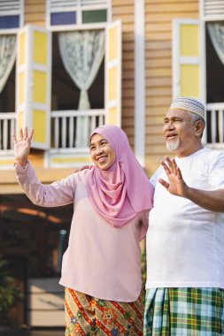 Gülümseyen yaşlı çift el sallıyor