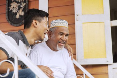 Baba ve oğul merdivenlerde sohbet ediyorlar.