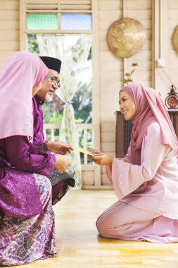 Üst düzey Müslüman kadın Kurban Bayramı 'nda kızından yeşil zarf alıyor.