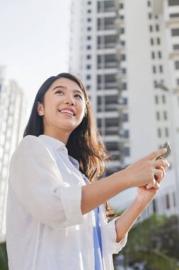 Akıllı telefon kullanan genç bir kadın.
