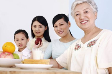 Üç kadın ve bir kız birlikte kahvaltı ediyorlar.