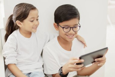 Dijital tabletli kız ve erkek kardeş