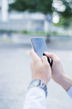 Dışarıda cep telefonu kullanan bir adam.