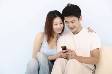 Erkek ve kadın mesajları birlikte okuyorlar.