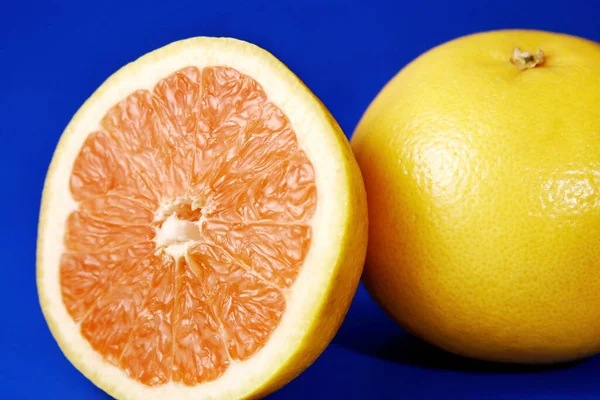 Egy Egész Egy Felezett Narancs Kék Háttér Mellett — Stock Fotó