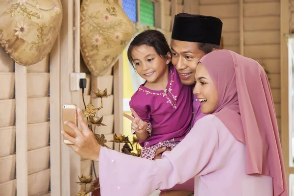 Malay family taking self-photograph with a smartphone