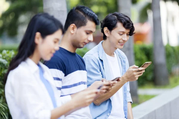 Trois Jeunes Adultes Utilisant Leur Smartphone — Photo