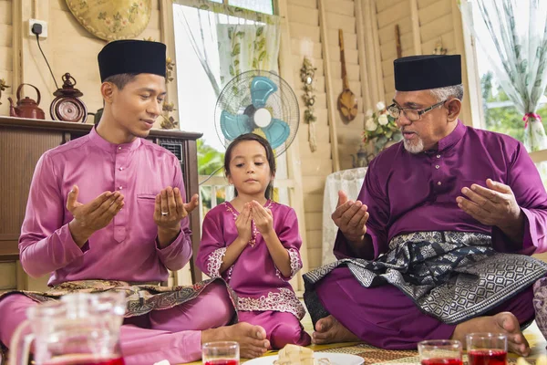 食事の前に祈るイスラム教徒の家族 — ストック写真