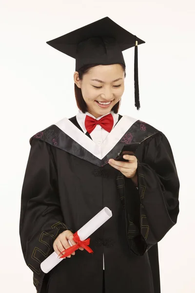 Woman Graduation Robe Text Messaging — Stock Photo, Image