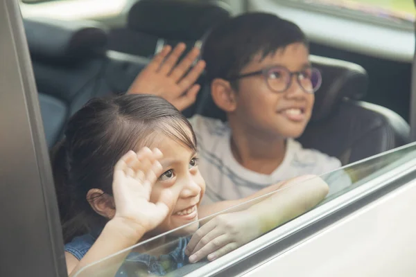 车上的孩子们抬起头挥挥手 — 图库照片