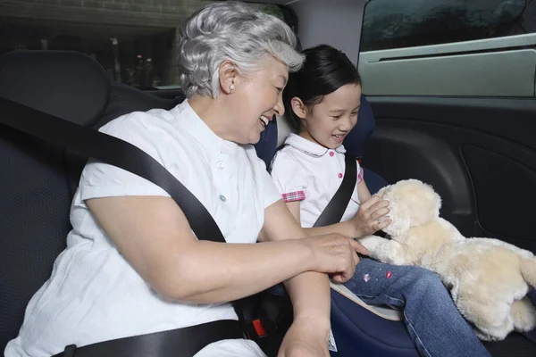 Seniorin Und Mädchen Sitzen Auto Und Spielen Stofftier — Stockfoto