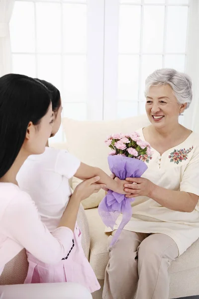 Gadis Yang Memberikan Karangan Bunga Untuk Wanita Senior Wanita Membimbing — Stok Foto