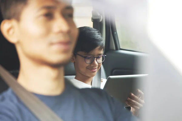 Pai Dirigindo Carro Enquanto Filho Está Usando Tablet Digital — Fotografia de Stock