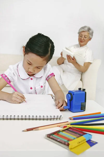 Girl Drawing Sketchbook While Senior Woman Reading Book Background — Stock Photo, Image