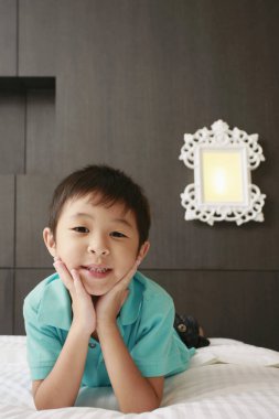 Yatakta ileri doğru uzanan çocuk