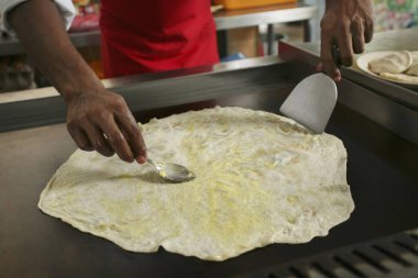Adam roti tisu hazırlıyor, margarin katıyor.