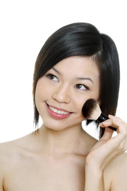 Yanağına allık süren bir kadın.