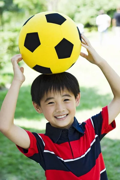 Menino Segurando Futebol Sua Cabeça — Fotografia de Stock