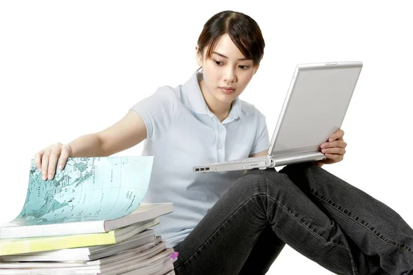 Kobieta Przeglądająca Książkę Podczas Korzystania Laptopa — Zdjęcie stockowe