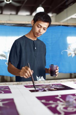 Batik kumaş boyayan adam.