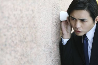 İş adamı bir bardaktan kulak misafiri oluyor.