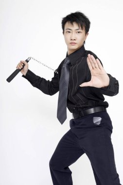 Nunchaku ile iş adamı kameraya poz veriyor.