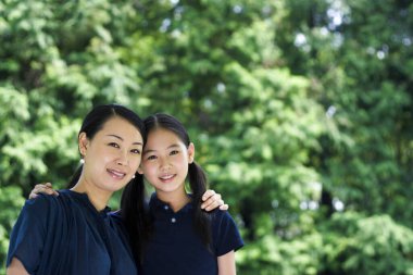 Anne ve kızı kameraya poz veriyor.