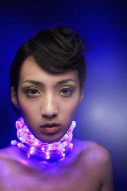 Boynunda ışıklı ışık şeridi olan bir kadın.