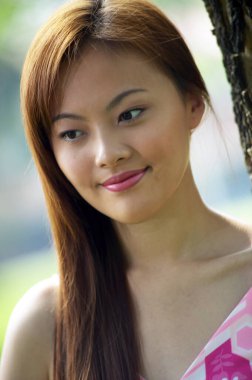 Bir kadın boş boş bakarken gülümsüyor.