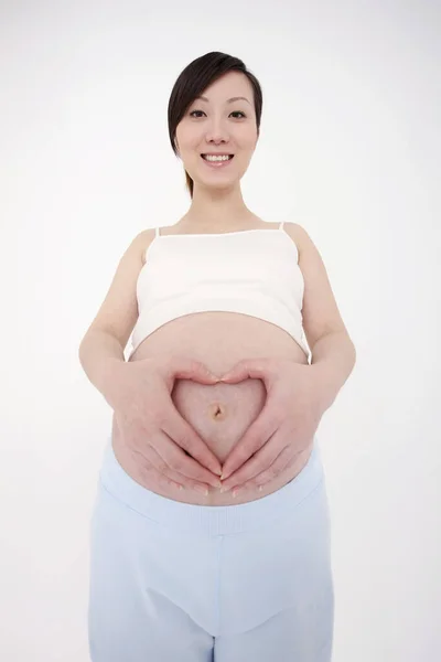 Gravid Kvinna Med Händer Som Bildar Hjärtform Över Naveln — Stockfoto