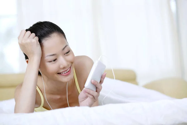 Жінка Лежить Ліжку Слухаючи Музику Портативному Mp3 Плеєрі — стокове фото