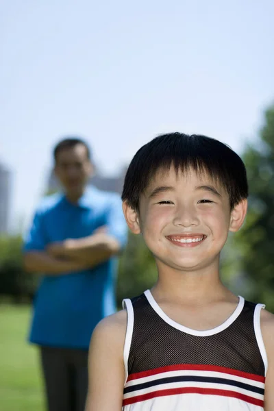 Junge Lächelt Während Sein Vater Hintergrund Steht — Stockfoto