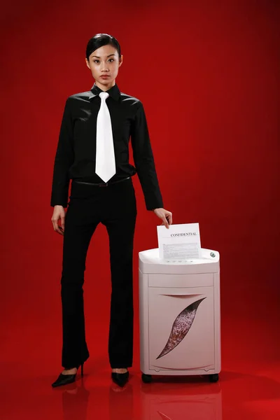 young businesswoman shredding paper