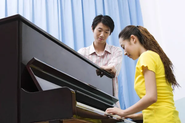 Молодой Человек Смотрит Молодая Женщина Играет Пианино — стоковое фото