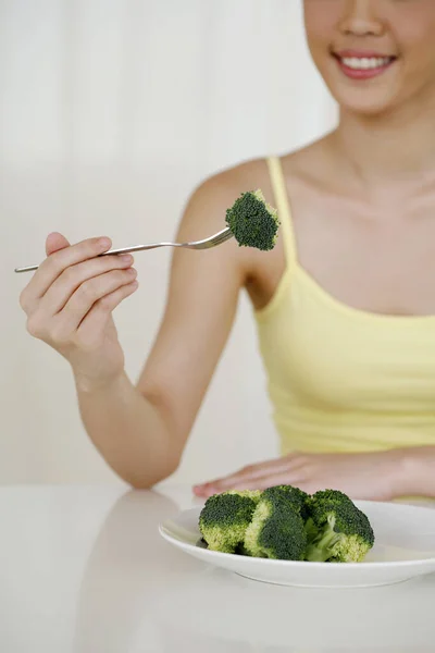 Ung Kvinna Äter Broccoli — Stockfoto