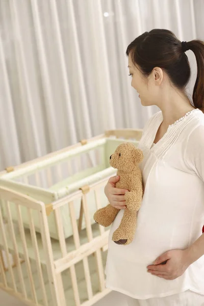 Gravid Kvinna Som Håller Nallebjörnen Och Tittar Vaggan — Stockfoto