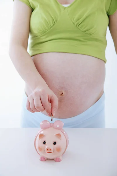 Schwangere Steckt Münze Sparschwein — Stockfoto