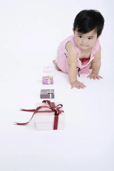 Baby Mädchen Krabbelt Neben Einer Reihe Von Geschenkboxen — Stockfoto