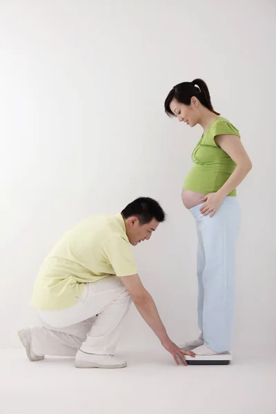 Mann Schaut Sich Maßstäbe Auf Denen Schwangere Stehen — Stockfoto