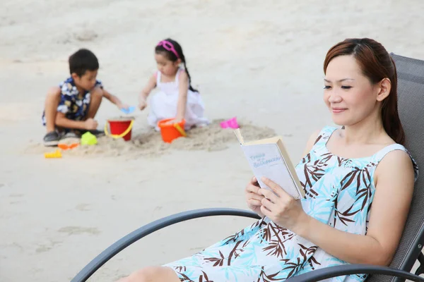 Žena Sedí Pláži Židle Čtení Knihy Chlapec Dívka Hraje Pískem — Stock fotografie