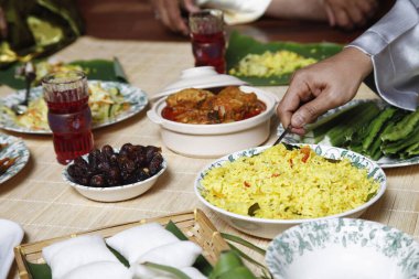 Nasi Briyani 'yi kepçeleyen adam, ön plandaki yemeğe odaklan.