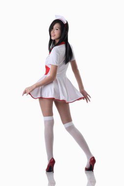 Hemşire kıyafetli kadın kameraya poz veriyor.