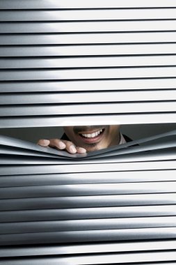 İş adamı perdelerden gözetliyor.