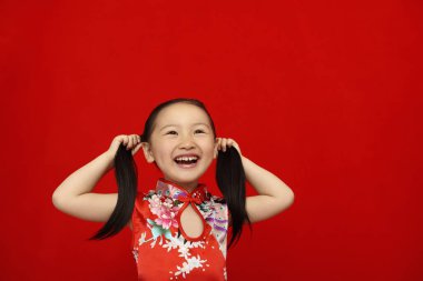 Kız saçlarını örerken gülüyor.