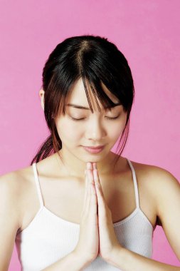 Ellerini birbirine kenetleyen bir kadın.