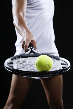 Tenis topunu raketin üstünde dengeleyen adam.