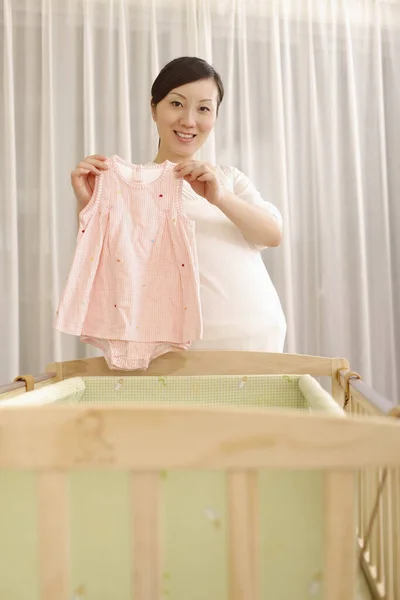 Schwangere Mit Babykleidung — Stockfoto